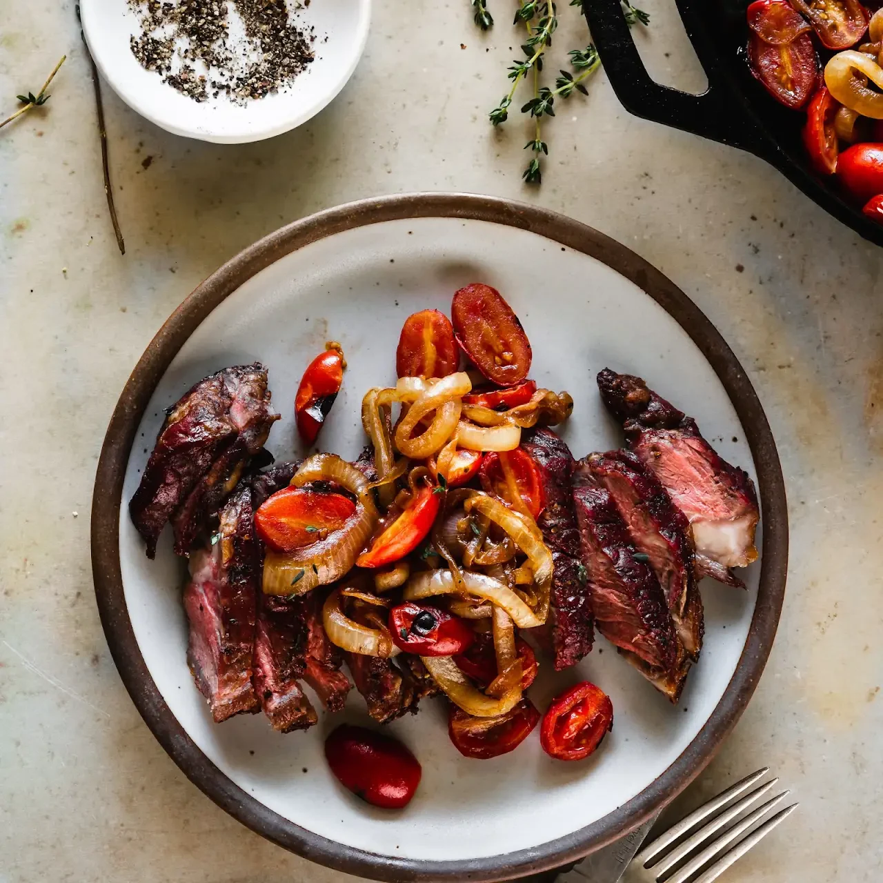 Grilled Garlic and Thyme Strip Steaks with Seared Onions and Tomatoes